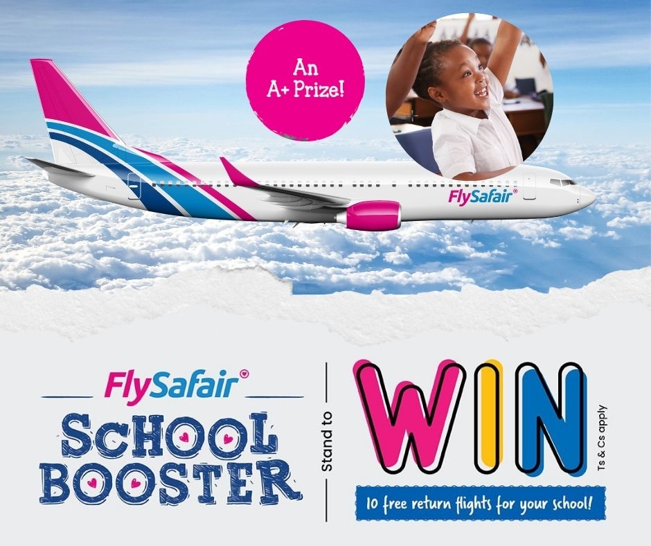 A diverse group of excited students in a classroom setting raise their hands in celebration. Laptops and backpacks scattered around the room suggest a collaborative effort. A banner in the background reads "FlySafair School Booster Competition" with an airplane icon. This image represents the opportunity for schools to win free domestic flights through participation in the competition.